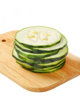 sliced zucchini on cutting board isolated on white