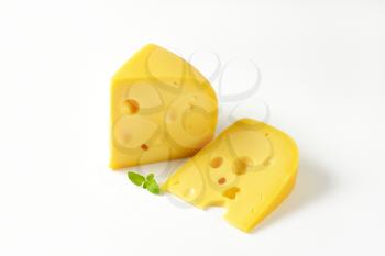 two wedges of Swiss cheese on white background