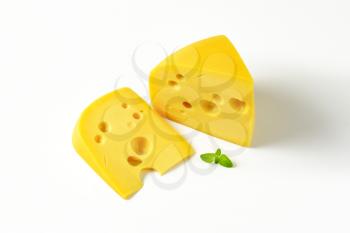 two wedges of Swiss cheese on white background
