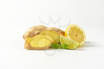 fresh ginger root with lemon and lime on white background