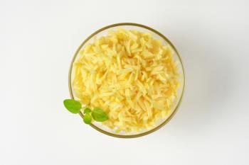 bowl of grated cheese on white background
