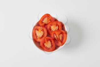 Fresh halved tomatoes in white bowl