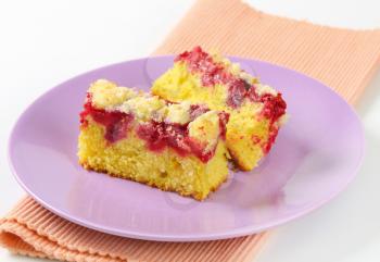 Pieces of raspberry crumb cake on purple plate