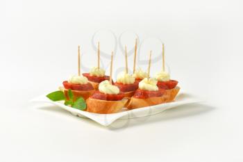 Bread based canapes with spicy sausage and creamy spread