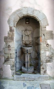 Ancient stone wall fountain in Volterra, Italy