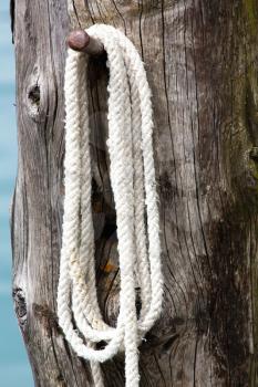 White mooring rope on wooden post
