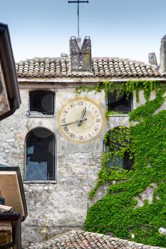 Ancient belfry covered with green ivy, Veneto, Italy