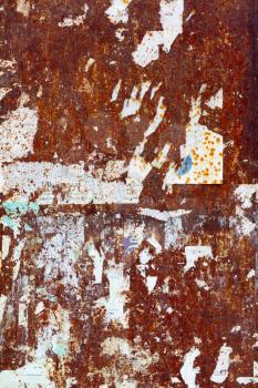 Scraped posters on rusty metal panel
