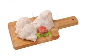 raw chicken thighs on wooden cutting board