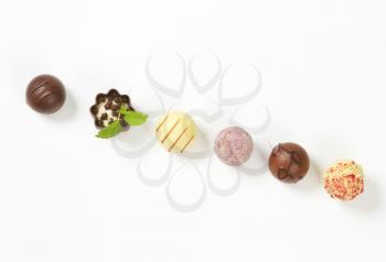 assorted belgian chocolate pralines in a row