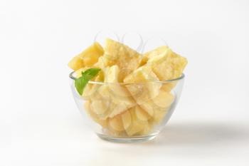 bowl of parmesan cheese pieces on white background