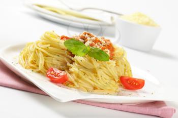 spaghetti with tomato pesto sprinkled with parmesan cheese