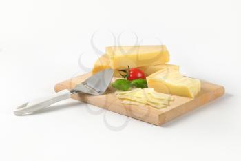 parmesan and cheese slicer on wooden cutting board