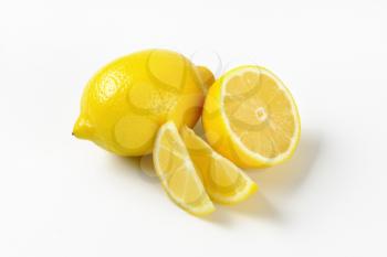whole and sliced juicy lemons on white background
