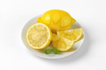 plate of whole and sliced lemons