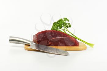 raw beef meat on wooden cutting board and chef's knife