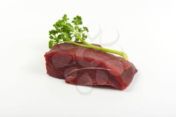 raw beef meat and fresh parsley on white background