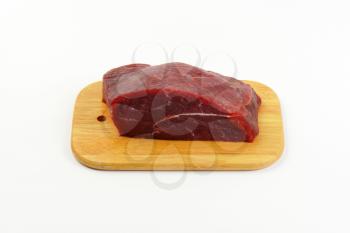 raw beef meat on wooden cutting board