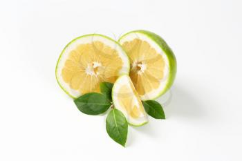 green grapefruit halves and slice on white background