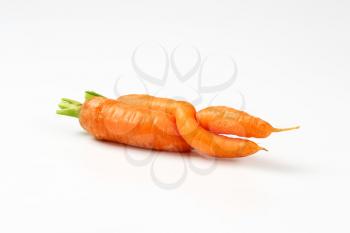 two twisted carrots on white background