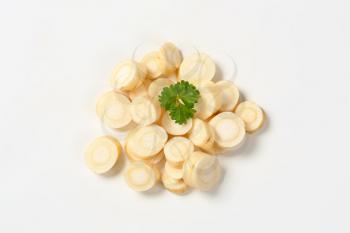 heap of sliced parsley root on white background