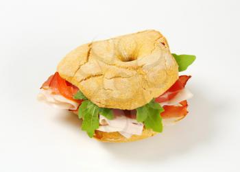 Ring-shaped bread roll with slices of prosciutto