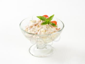 Ham and potato salad in glass serving bowl