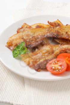 Pan fried side pork bacon slices on plate