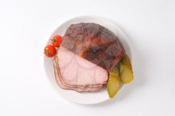 Smoked pork roast with gherkins and tomatoes on plate