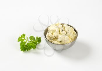 bowl of homemade cheese spread with herbs on white background