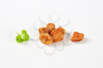 handful of pork scratchings on white background