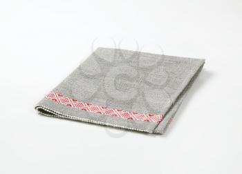 grey place mat with red decorative stripe