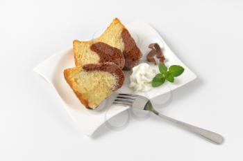 slices of marble bundt cake and whipped cream on white plate