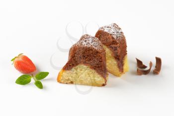 two slices of marble bundt cake on white background