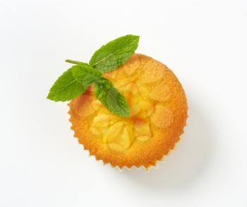 Custard filled lemon cupcake on white background
