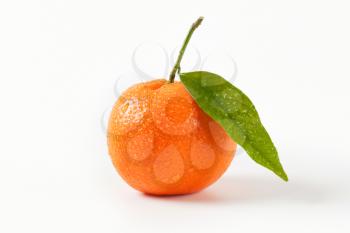 washed tangerine with leaf on white background