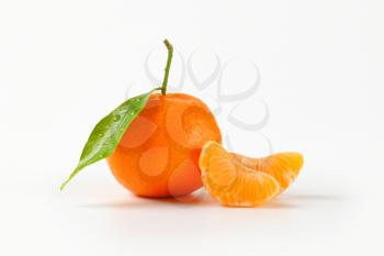 freshly washed tangerine with separated segments on white background