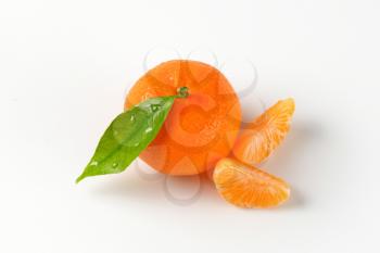 freshly washed tangerine with separated segments on white background