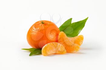 whole tangerine with separated segments on white background