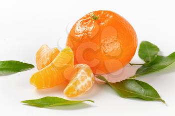 whole mandarin with separated segments and leaves