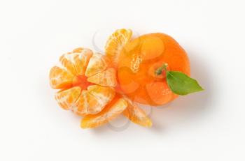 peeled and unpeeled tangerines on white background