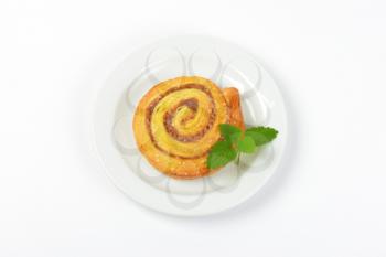 sweet cinnamon roll on white plate