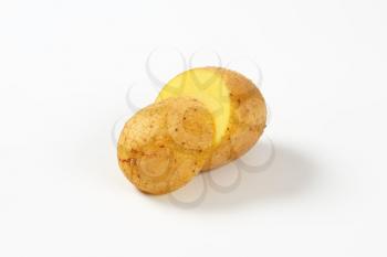 halved raw potato on white background