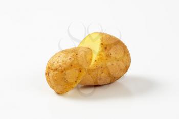 halved raw potato on white background