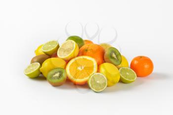 assortment of fresh citrus fruits and kiwi on white background