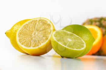 close up of limes and lemons on white background