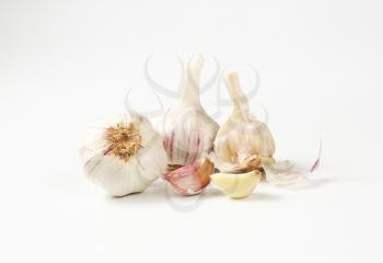 Fresh garlic bulbs and cloves on white background