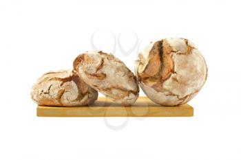 three round loaves of bread on wooden cutting board
