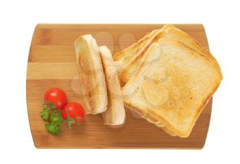 toasted white bread slices on wooden cutting board