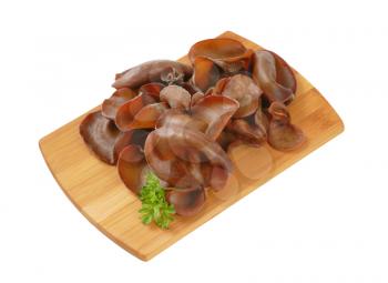 heap of wood ear mushrooms on wooden cutting board